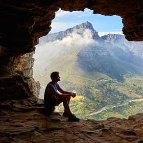 man in a cave on top of a mountain